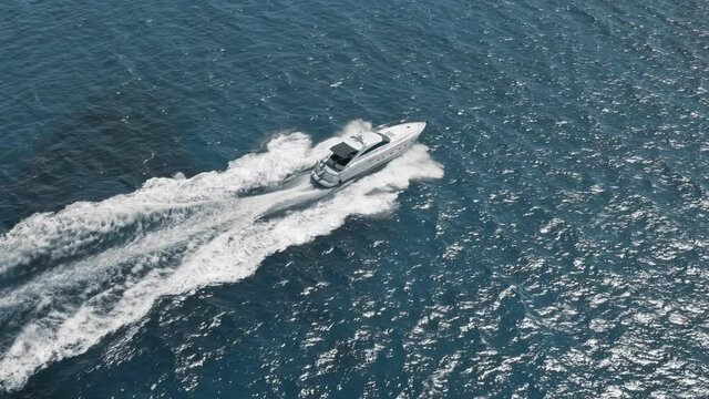 Aerial white motor boat yacht cruise sail in blue sea water, Maiami, USA. Drone tracking of sailboat voyage in coastal seaside resort. Active marine summer vacation, ocean travel. Slow motion