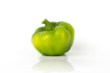 Raw green bell pepper on the glossy background