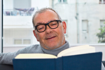 mature man reading on the sofa at home