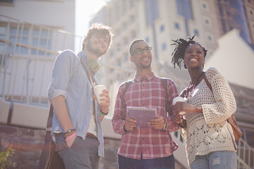 Friends using digital tablet on city street