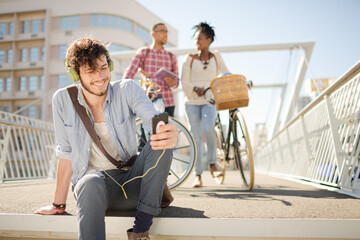 Man listening to headphones on city street