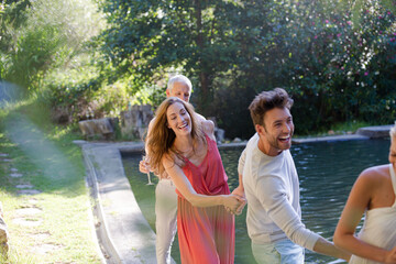 Friends holding hands by pool