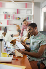 Man eating and working at conference tablet
