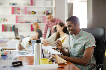Man eating and working at conference tablet