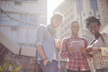 Friends using digital tablet on city street