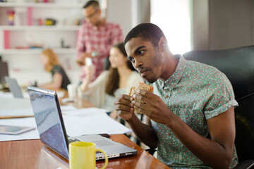 Man eating and working at conference tablet