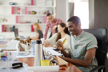 Man eating and working at conference tablet
