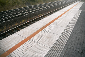 Train platform with tactile dotted pavement for handicapped people. City transportation...