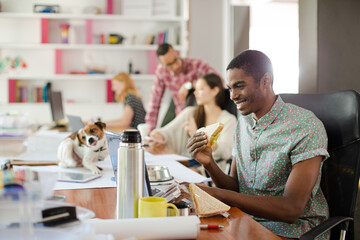 Man eating and working at conference tablet