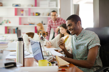 Man eating and working at conference tablet