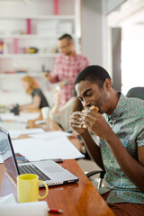 Man eating and working at conference tablet