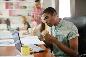 Man eating and working at conference tablet