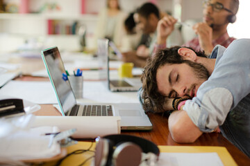 Man sleeping at desk in office