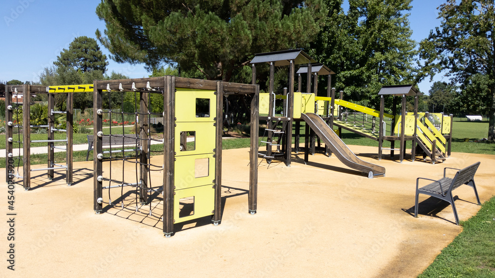 Wall mural children colored green and steel wooden slides colorful playground on park street