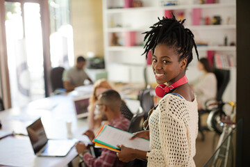 Woman carrying folders in office