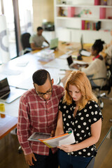 People reading folders in office