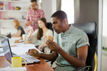 Man eating and working at conference tablet