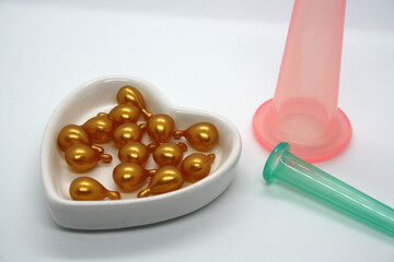 A jar for facial massage and gold capsules with oil.