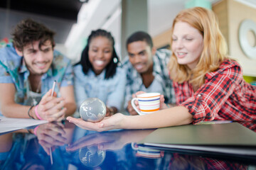 People examining miniature globe