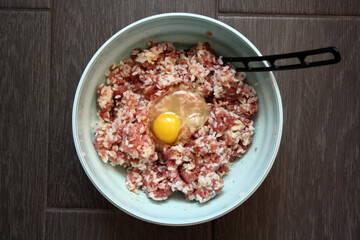 Minced meat, egg and rice in a bowl. Cooking meatballs.