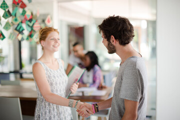 People shaking hands in office