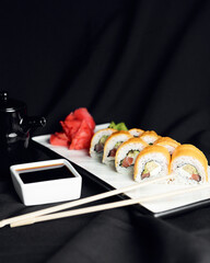 Sushi Rolls with processed cheese cheddar, american cheese, avocado, tuna and cream cheese inside on white slate