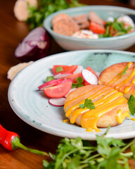 Grilled burgers with sauce and vegetable radish salad on a plate on a rustic wooden table background.