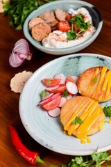 Grilled burgers with sauce and vegetable radish salad on a plate on a rustic wooden table background.