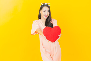 Portrait beautiful young asian woman smile with heart pillow shape