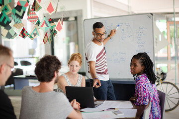 Man drawing on white board for colleagues