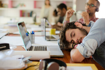 Man sleeping at desk in office