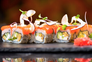 Philadelphia Maki Sushi set with salmon, passion fruit sauce and coconut chips on top. Sushi menu. Japanese food.