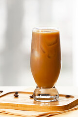 Glass of tasty iced coffee on table