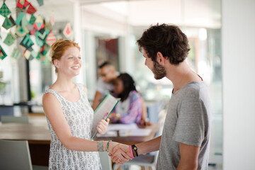 People shaking hands in office