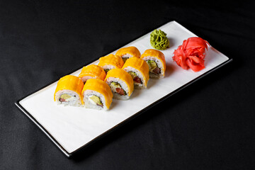Sushi Rolls with processed cheese cheddar, american cheese, avocado, tuna and cream cheese inside on white slate