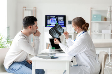 Obraz premium Female doctor showing x-ray scan to patient in clinic