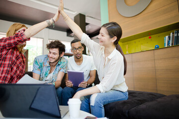 People high fiving in office