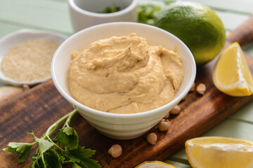 Bowl with tasty hummus on table, closeup