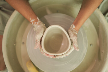 Anonymous artisan creating vase on wheel