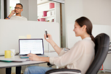 Woman using cell phone in office