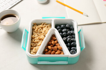 Lunch box with tasty food and cup of coffee on light background