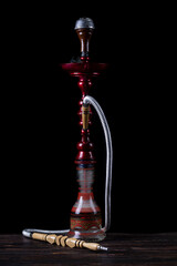 close-up. Hookah with a glass flask and a metal bowl hookah without smoke. Black background. Front view.