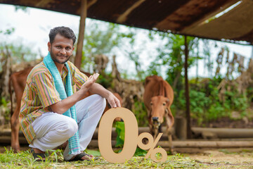 Banking or financial concept : Young indian farmer showing zero percent symbol at his cattle farm