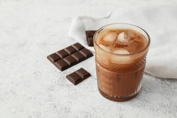 Glass of tasty chocolate milk on light background