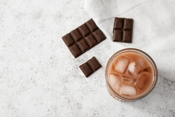 Glass of tasty chocolate milk on light background