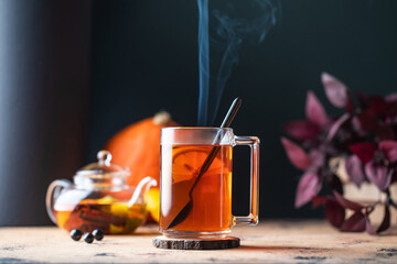 A mug of hot tea with lemon and steam. Autumn time.