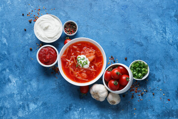 Bowl of tasty borscht and ingredients on color background