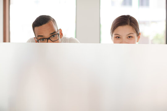 People Peeking Over Cubicle In Office