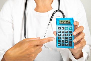 Ärztin am Schreibtisch mit einem Taschenrechner auf dem Corona steht