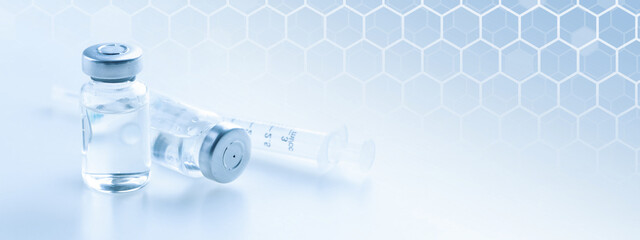 Medical syringe with a needle and a bollte with vaccine.